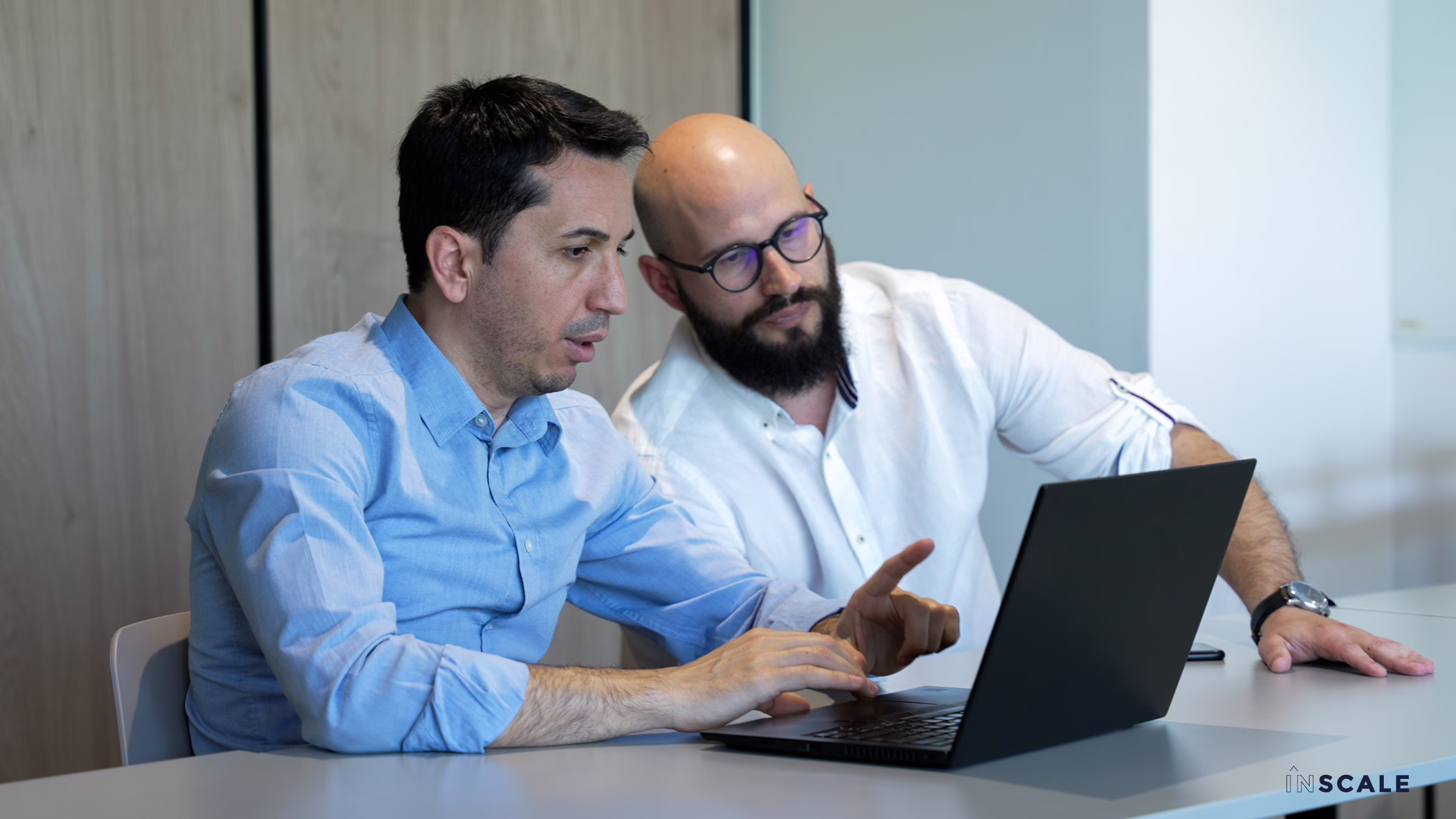 INSCALE employees working on a laptop